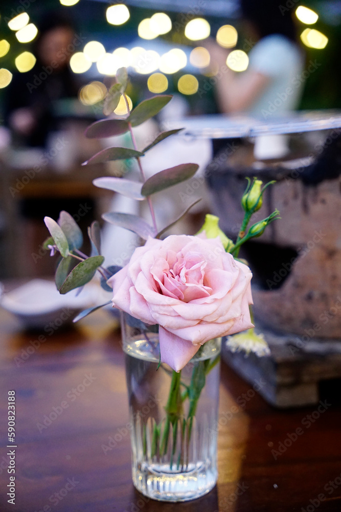Fototapeta premium Aesthetic simple pastel rose vase with eucalyptus leaves at event table