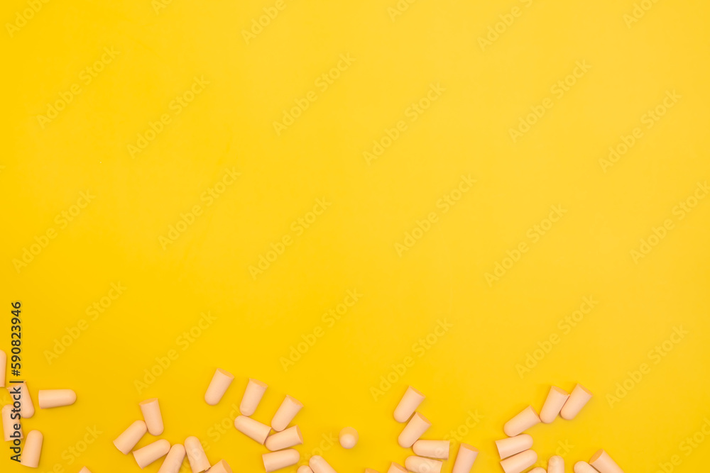 Ear plugs on a yellow background with copy space for text