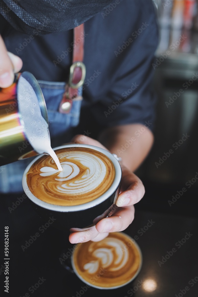 Fototapeta premium Barista making latte in coffee bar.
