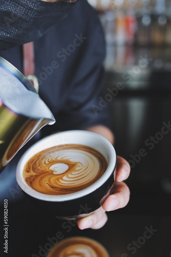 Barista making latte in coffee bar.