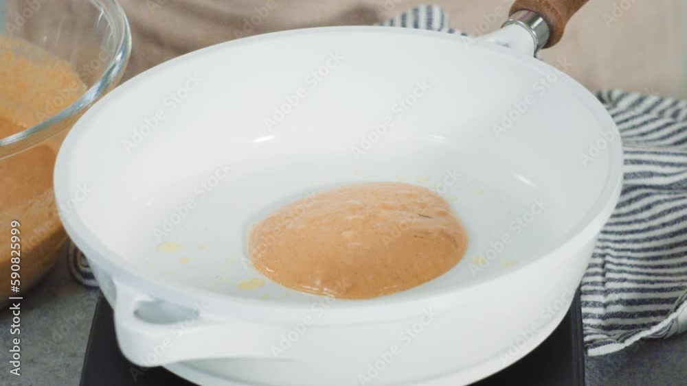Step by step. Frying pumpkin pancakes batter on a white frying pan. Step by step. Frying pumpkin pancakes batter on a white frying pan.