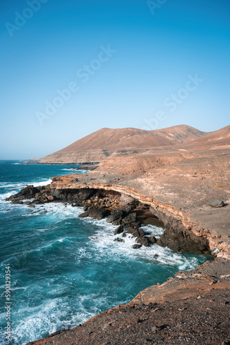 Obraz na płótnie Stunning view of a rocky coastline bathed by a beautiful blue ocean. Playa del Aguila (Eagles' Beach) Fuerteventura, Canary Islands, Spain... w salonie