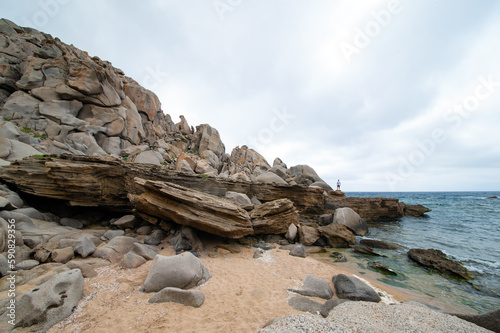 Obraz na płótnie Stunning view of a person on some rocks in Valle della Luna. Cala Grande is located in the western part of the promontory of Capo Testa, in the territory of Santa Teresa Gallura, Sardinia, Italy. w salonie