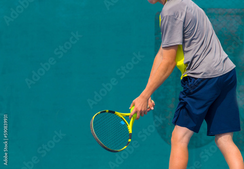 Tennis player playing tennis on a hard court on a bright sunny day  © Павел Мещеряков