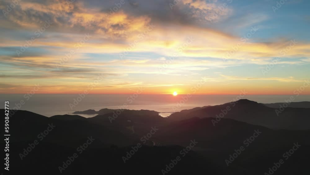 Beautiful sunset color in sky over ocean and hilly coastal landscape Beautiful sunset color in sky over ocean and hilly coastal landscape