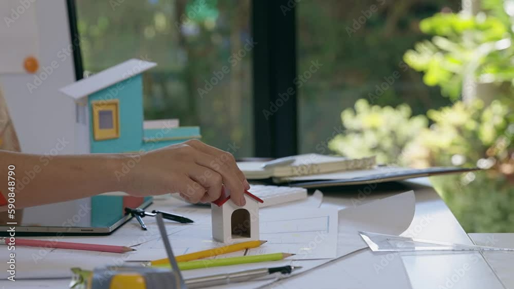 Architect woman model house on office desk with shop drawing paper in ...