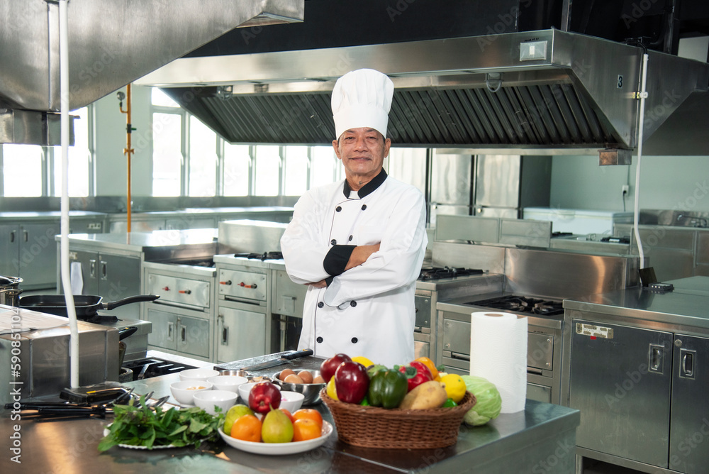 Happy Man Asia standing with arms crossed while working as chef in a restaurant Happy Man Asia standing with arms crossed while working as chef in a restaurant
