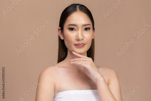 Beautiful Asian woman touching eyebrow smile with clean and fresh skin Happiness with positive emotional,isolated on Beige background,Beauty Cosmetics and spa Facial treatment Concept.