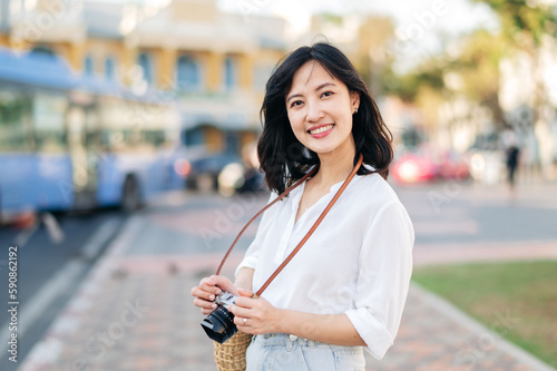 Portrait beautiful asian woman traveler with camera explore street on summer vacation in Bangkok, Thailand photo