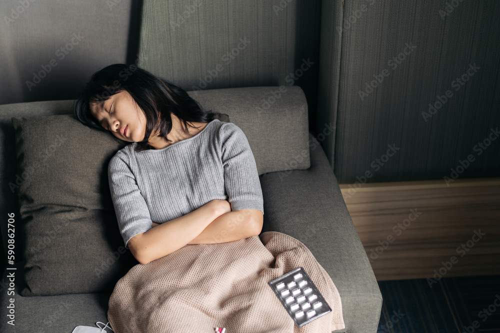 Asian woman with cold and flu sleeping on sofa bed at home. Stock Photo