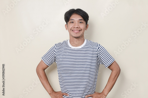 Wallpaper Mural Young man in striped shirt with smiling expression relaxed on isolated background Torontodigital.ca