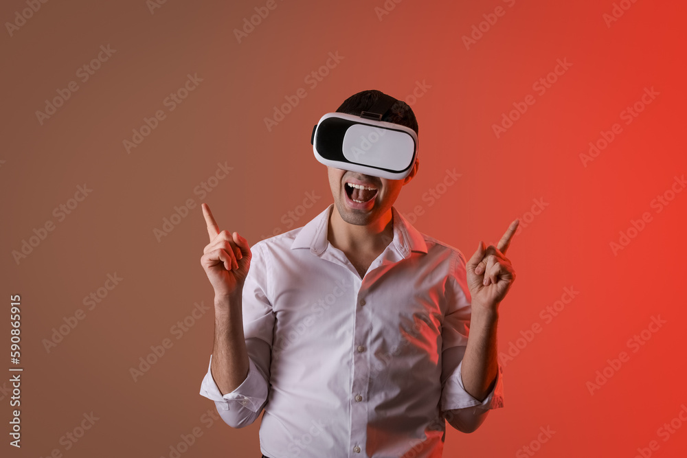 Young man using VR glasses on color background Young man using VR glasses on color background