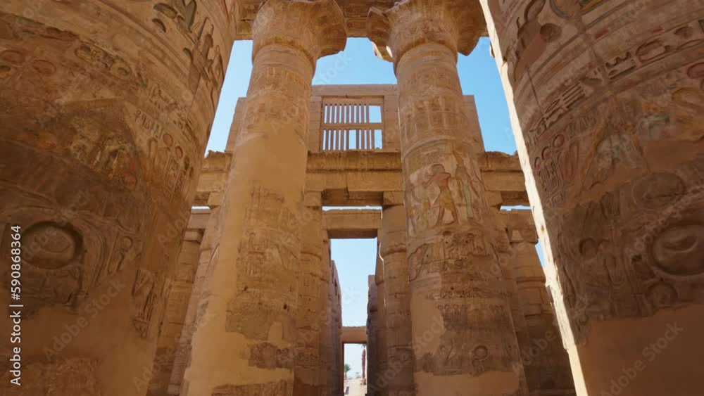 Karnak Temple in Luxor, Egypt. Camera moves between majestic columns with ancient Egyptian drawings. Gimbal high quality shot