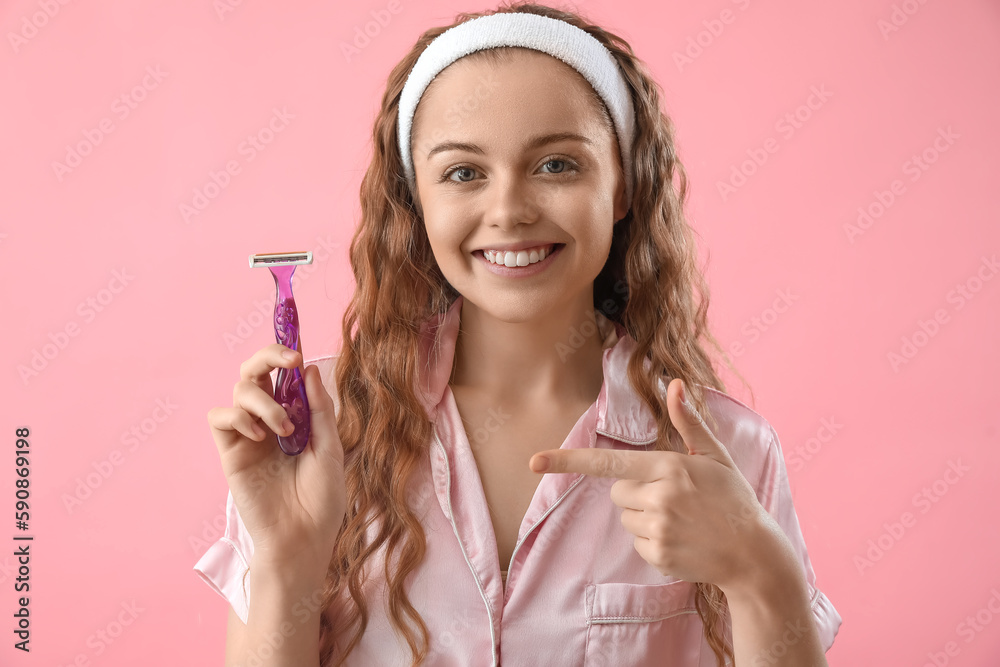Young woman pointing at razor on pink background Young woman pointing at razor on pink background