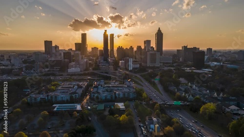 hyper lapse aerial drone footage of Atlanta downtown skyscraper  during sunsets. the bright orange sun goes down between the building architectures related to urban travel, vacations and traffic 