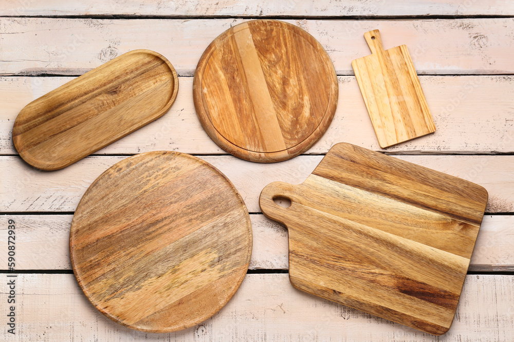 Set of different cutting boards on light wooden background