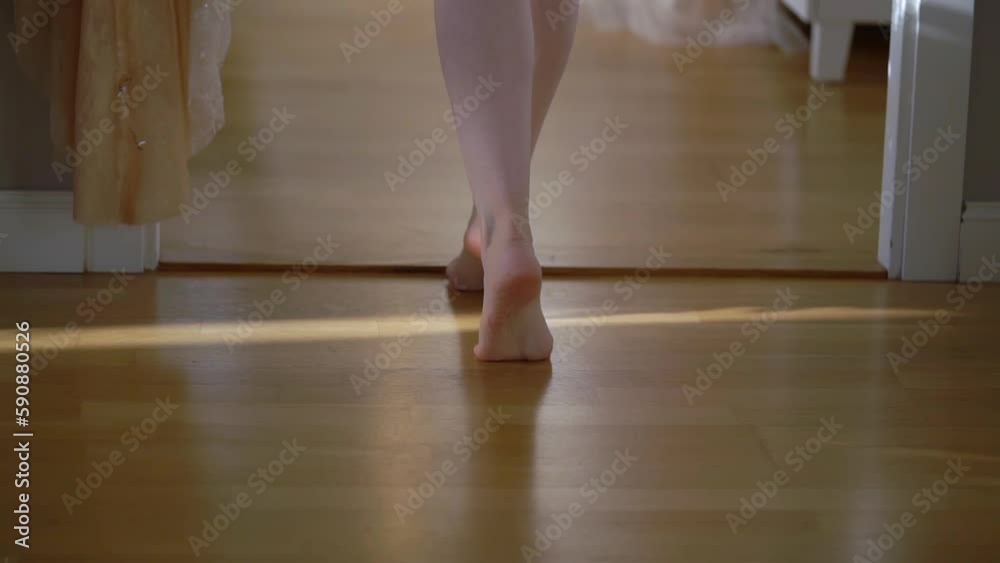 A young woman walks barefoot to her wedding dress. The bride is getting dressed. Female legs goes in bedroom. A young woman walks barefoot to her wedding dress. The bride is getting dressed. Female legs goes in bedroom.