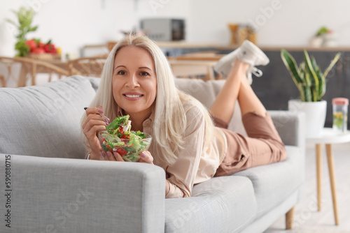 Mature woman eating vegetab...