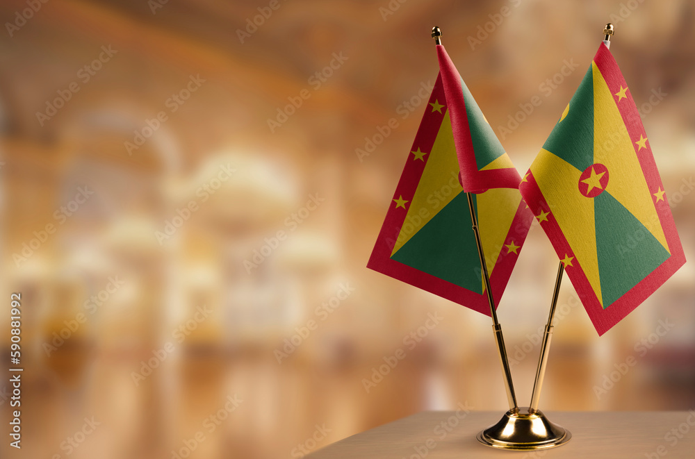 Small flags of the Grenada on an abstract blurry background
