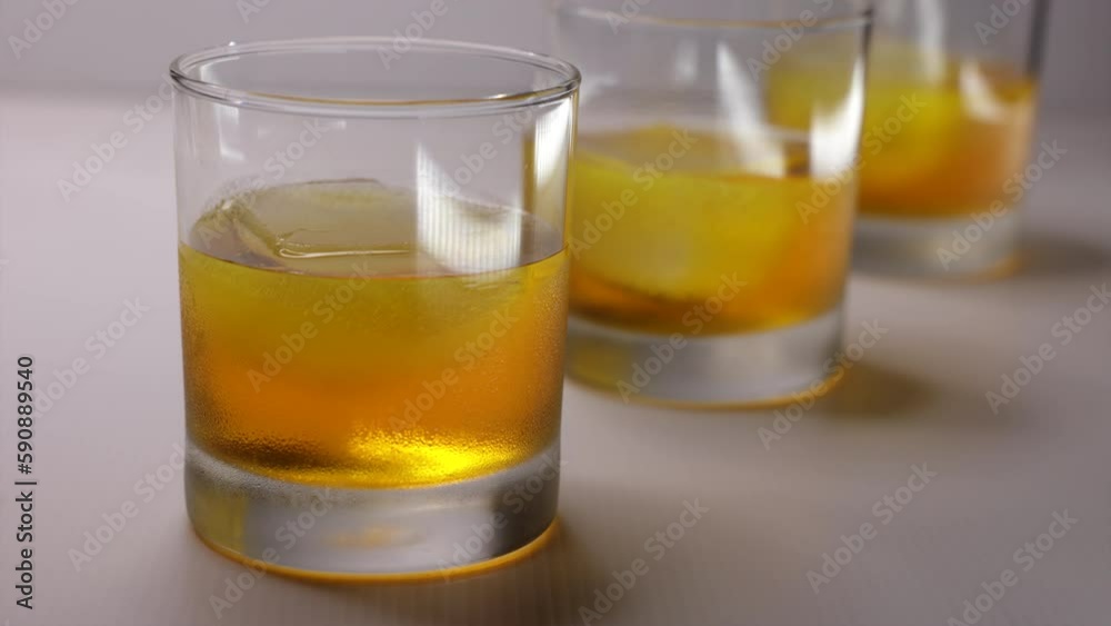 Whiskey glasses in a row and melting ice cubes - Time Lapse Clip on white backdrop Whiskey glasses in a row and melting ice cubes - Time Lapse Clip on white backdrop