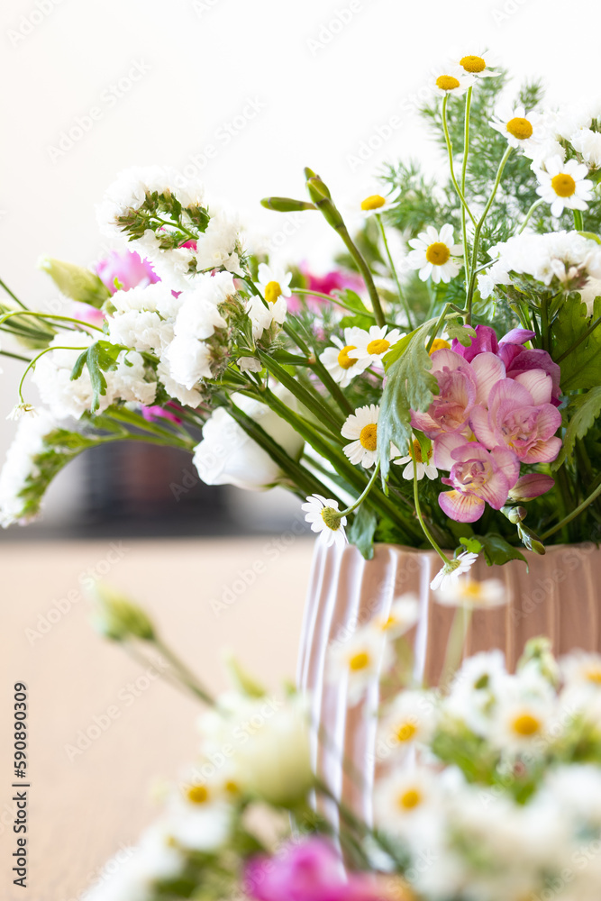 Two modern design vases with flowers like daisies and freesias in spring. Countryside spring flowers, nature and floral beauty..Spring time, colorful greenery and change of season