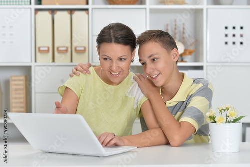 mother and son using modern laptop at the table