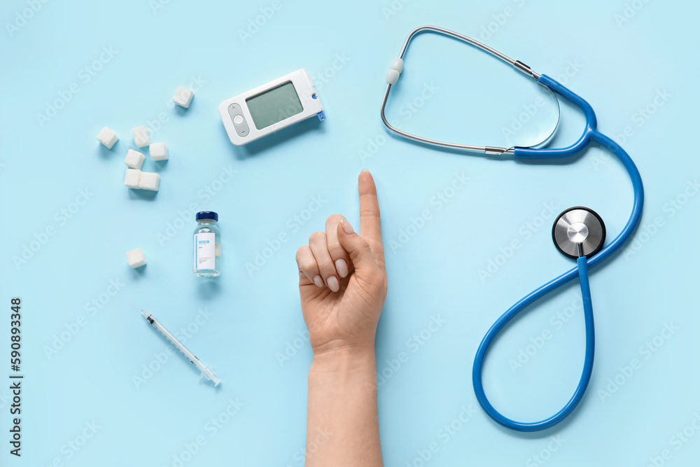Woman with insulin, sugar, glucometer and stethoscope on blue background. Diabetes concept Woman with insulin, sugar, glucometer and stethoscope on blue background. Diabetes concept