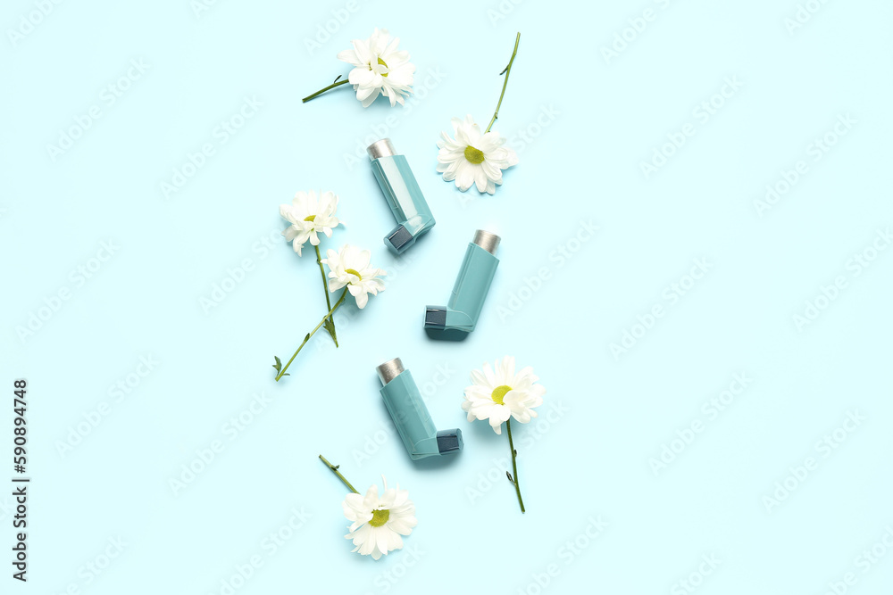 Asthma inhalers with daisy flowers on blue background Asthma inhalers with daisy flowers on blue background