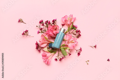 Asthma inhaler with flowers on pink background