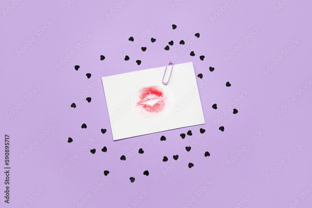 Paper with lipstick kiss mark and hearts on lilac background