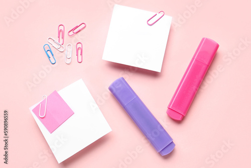 Sticky notes with paper clips and markers on pink background
