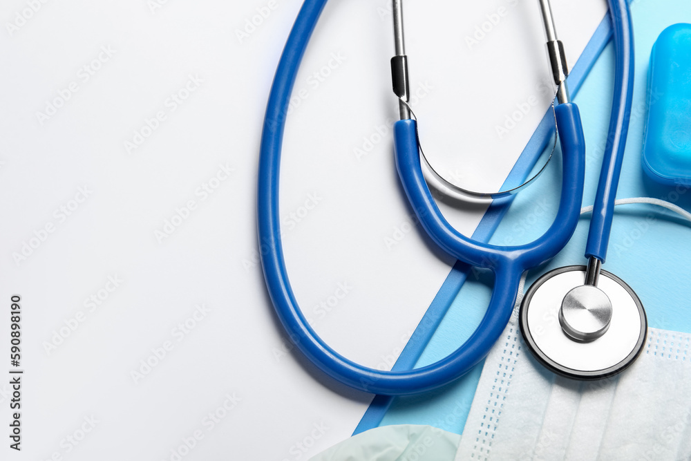 Stethoscope, clipboard and medical mask on blue background, closeup Stethoscope, clipboard and medical mask on blue background, closeup