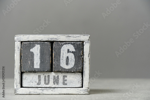Calendar for June 16, made wooden cubes, on gray background.With an empty space for your text. photo