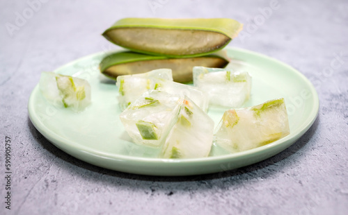 Closeup Aloe Vera Plant And Aloe Juice Ice Cubes On Green Plate On Table. Top View. Horizontal plane. Natural Homemade Cosmetics, DIY Concept. Food, Medicine And Beauty Industry