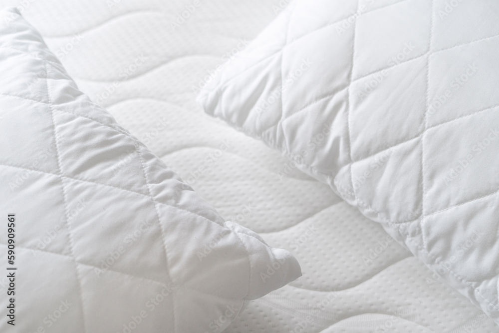 background of soft pillows on white quilted mattress