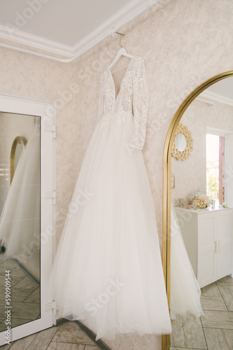 Beautiful white wedding dress of the bride hanging on a hanger