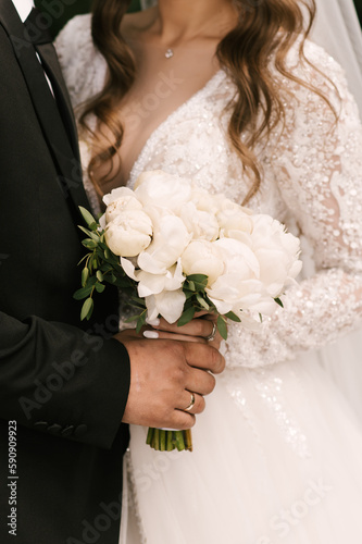Obraz na płótnie Beautiful white wedding bouquet of peonies in the hands of the bride w salonie