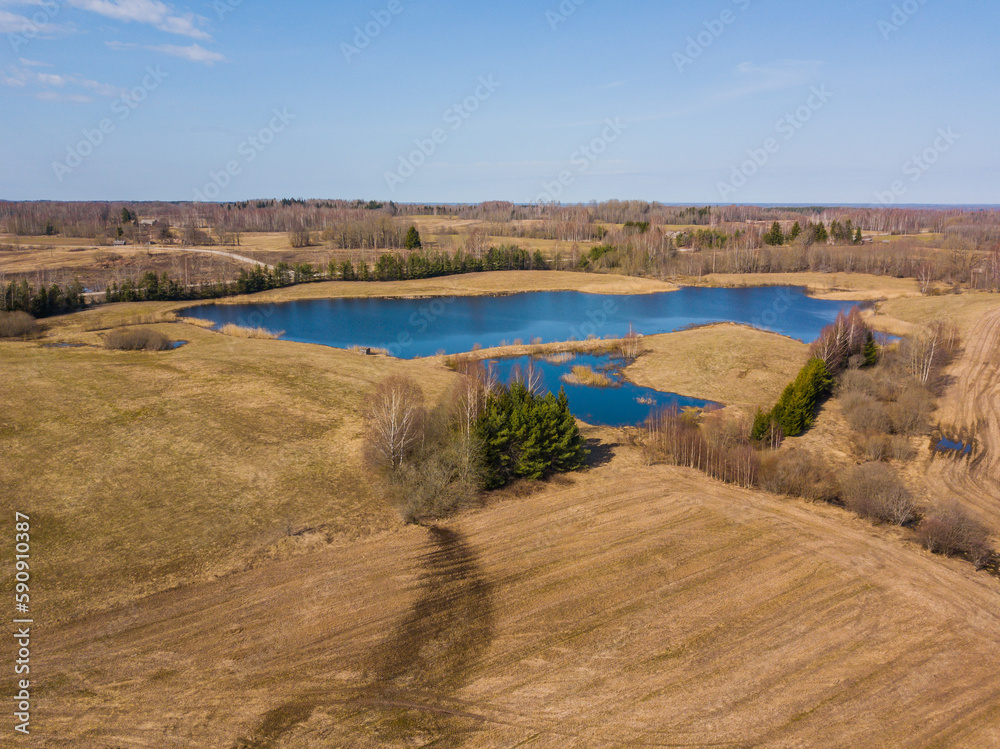 Blue lake next to a forest aerial view in Latgale, Latvia