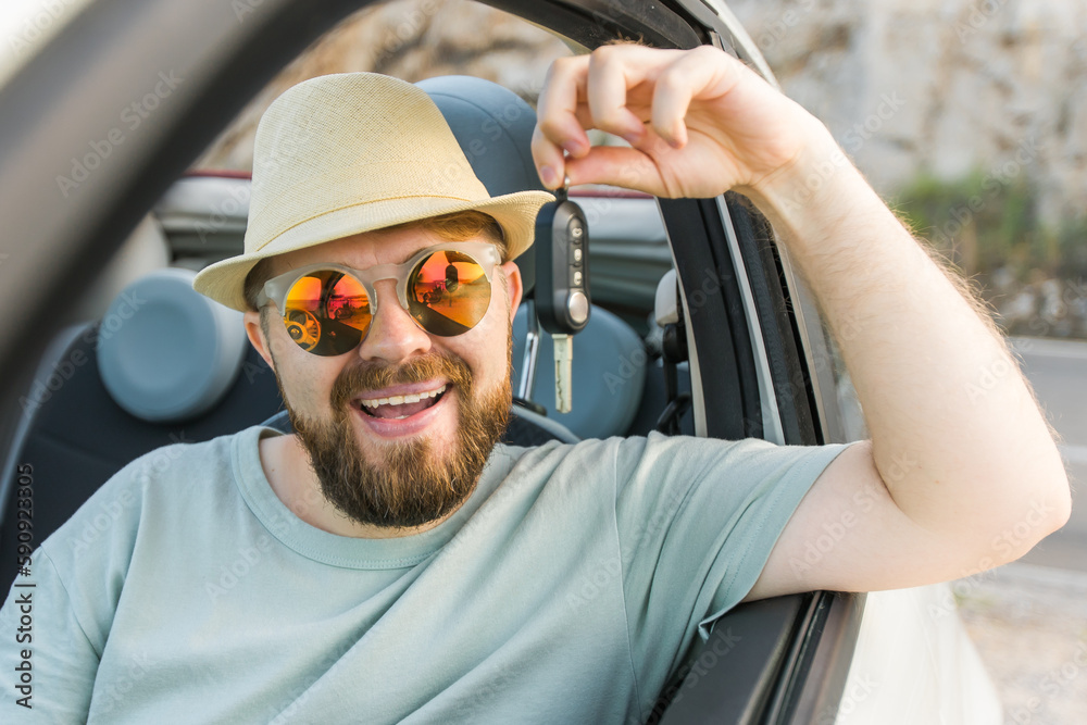 Naklejka premium Handsome happy man showing key of new car - Rental and buy new car concept