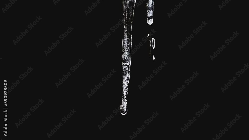 Drips falling from melting icicles against a dark background. Drips falling from melting icicles against a dark background.