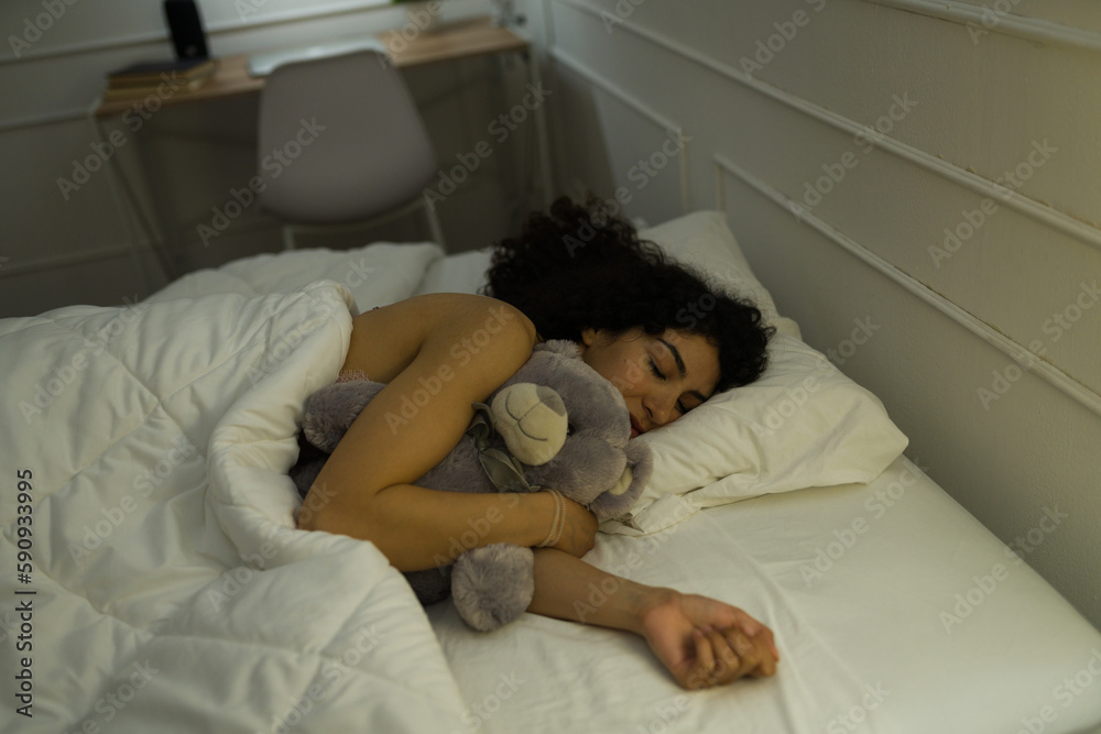 Smiling woman hugging her teddy bear sleeping Smiling woman hugging her teddy bear sleeping