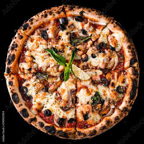 Italian kitchen pizza with salmon, onion, olives, cheese, basil, tomato sauce, lime and spices isolated on black.