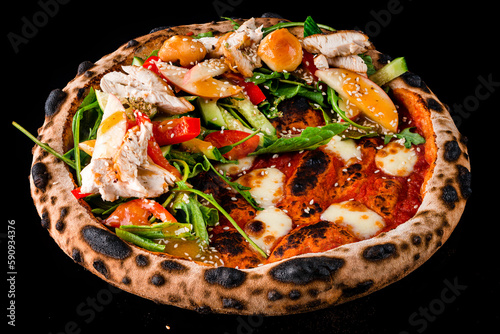 Pizza Margherita with mozzarella cheese and tomato sauce and a salad of cucumbers, chicken, sweet peppers, tomatoes, apples, arugula and lettuce isolated on black.