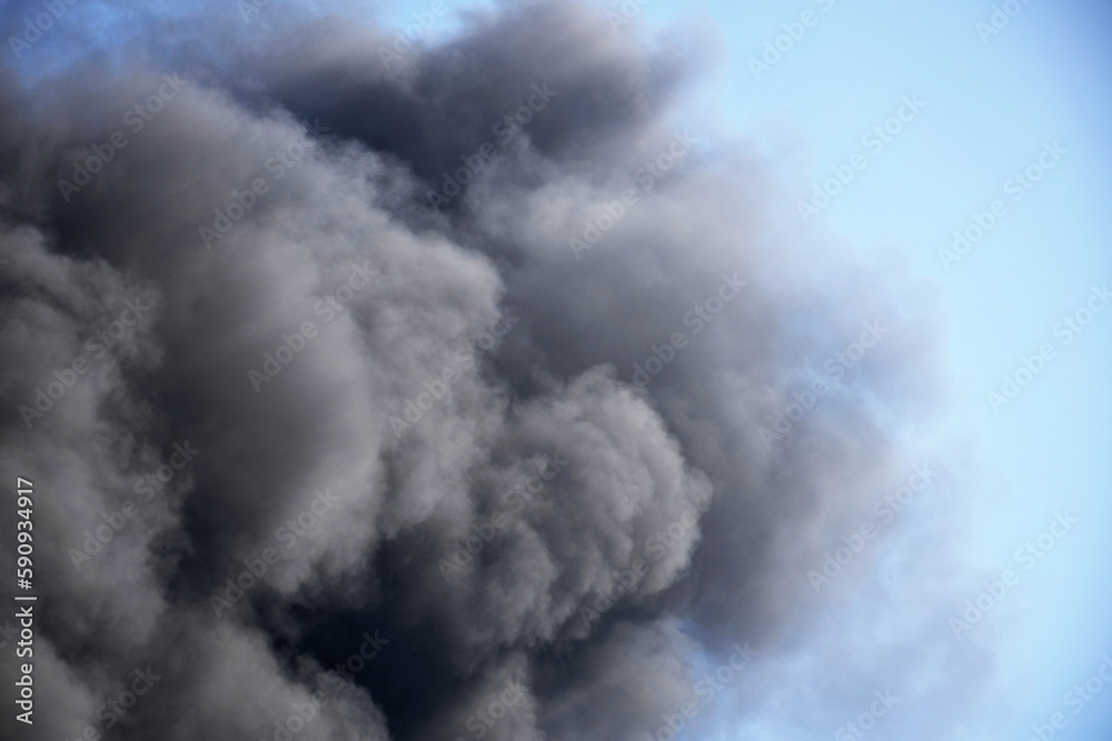 Huge clouds of smoke against the sky, a large fire at a construction site.