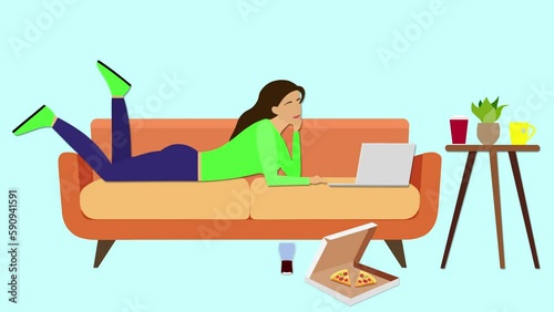 Goblin mode concept. The girl is lying on the couch looking at her laptop, with a pizza box and a glass of soda on the floor. Goblin mode, or a state of indifference, slackness, and refusal to work