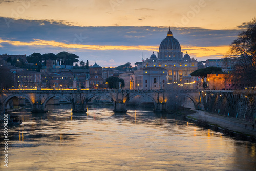 Cityscape with Sant Angelo bridge and St. Peter's cathedral at sunset with city lights in Rome, Italy © p_rocha