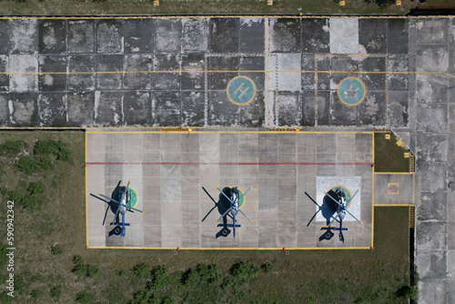 Tres helicópteros estacionados en un aeropuerto photo