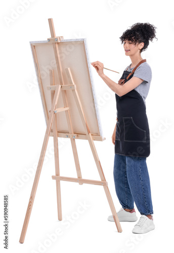 Young woman painting on easel with canvas against white background