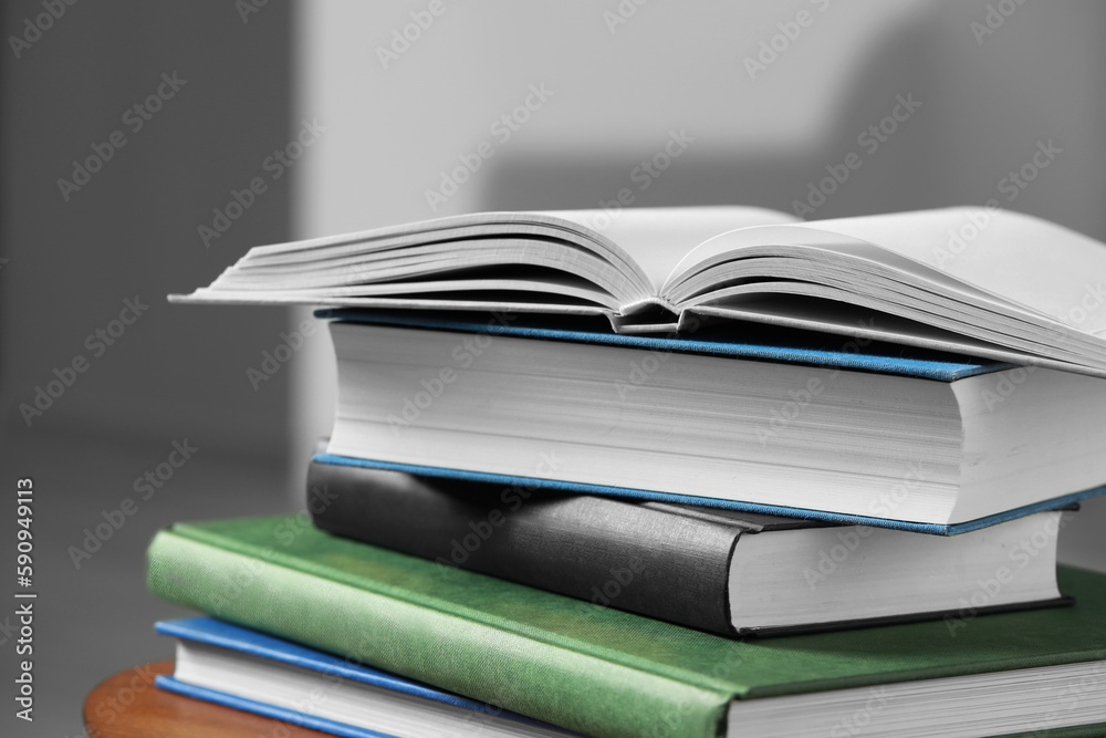 Fototapeta premium Stack of hardcover books on wooden table, closeup