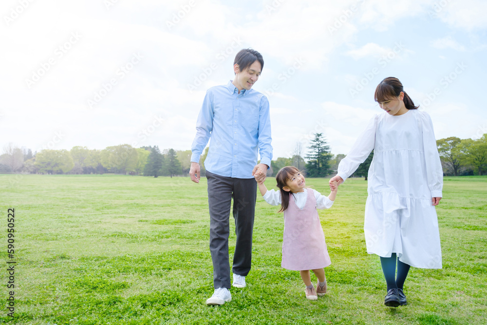 Obraz premium 公園で手を繋いで歩く家族